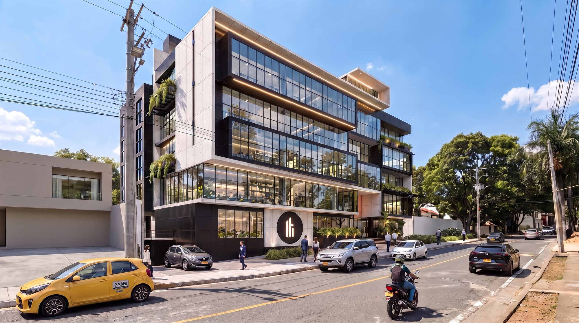 El edificio desde la vía: cinco pisos de oficinas en concreto a la vista y ventanería continua, con el acceso peatonal y el medallón del logotipo sobre la fachada del primer piso.